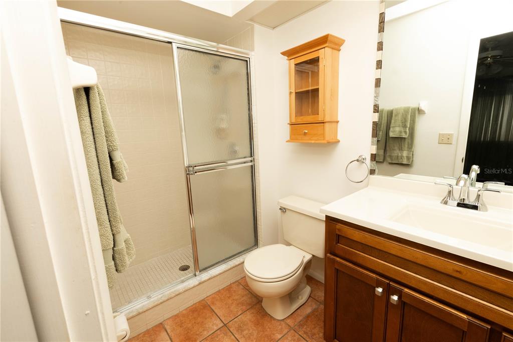 9410 Nakoma Way, Unit H Weeki Wachee, FL 34613 - Photo 20 of 29 a bathroom with a sink a toilet a mirror and shower