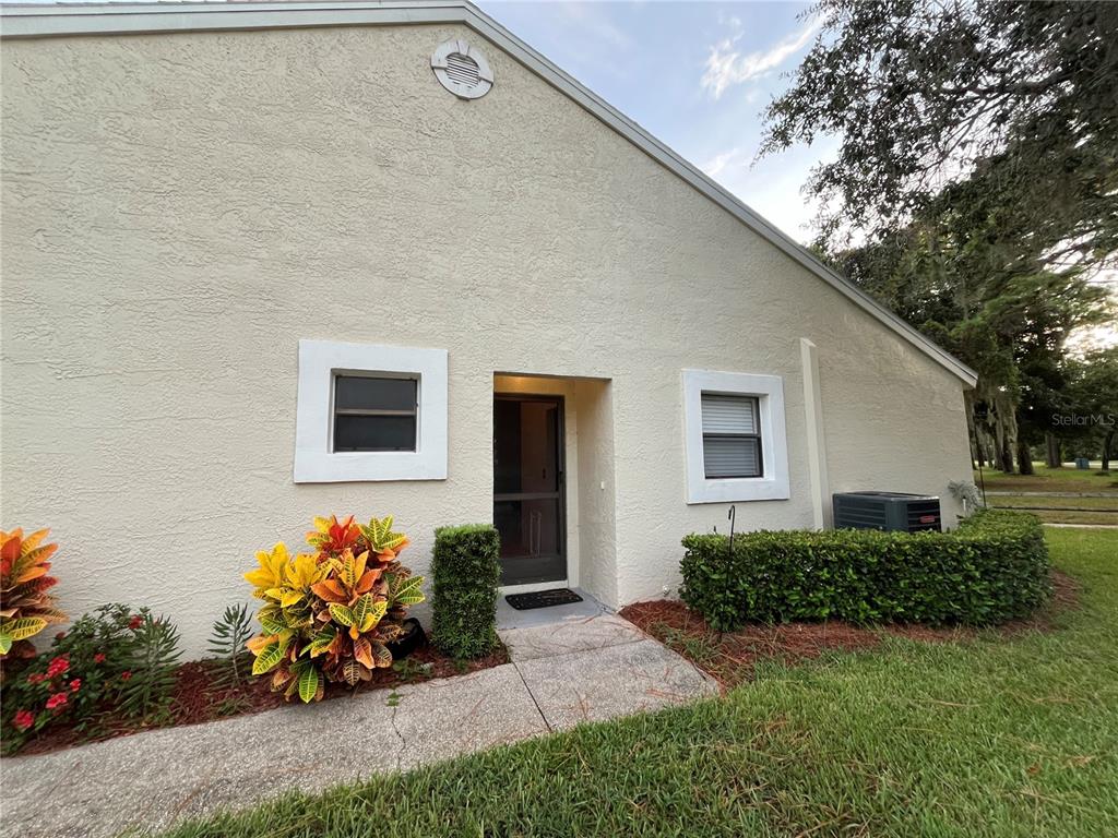 9410 Nakoma Way, Unit H Weeki Wachee, FL 34613 - Photo 2 of 29 a front view of a house with lots of flowers in it