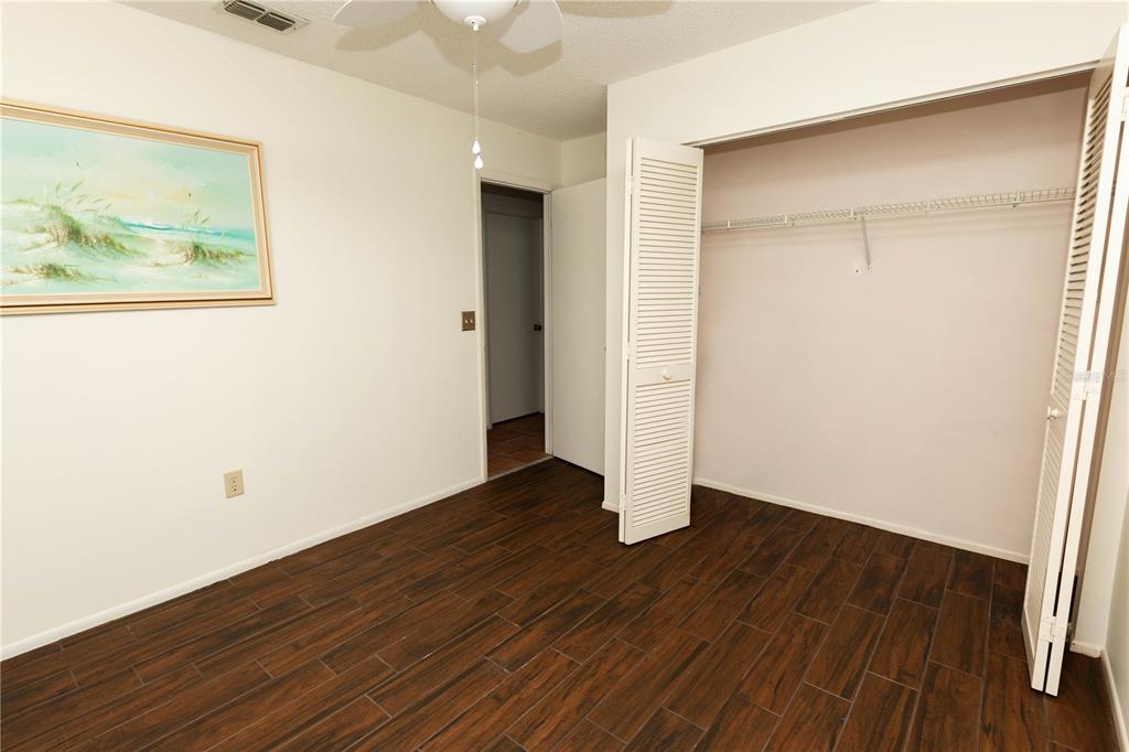 9410 Nakoma Way, Unit H Weeki Wachee, FL 34613 - Photo 21 of 29 an empty room with wooden floor and closet