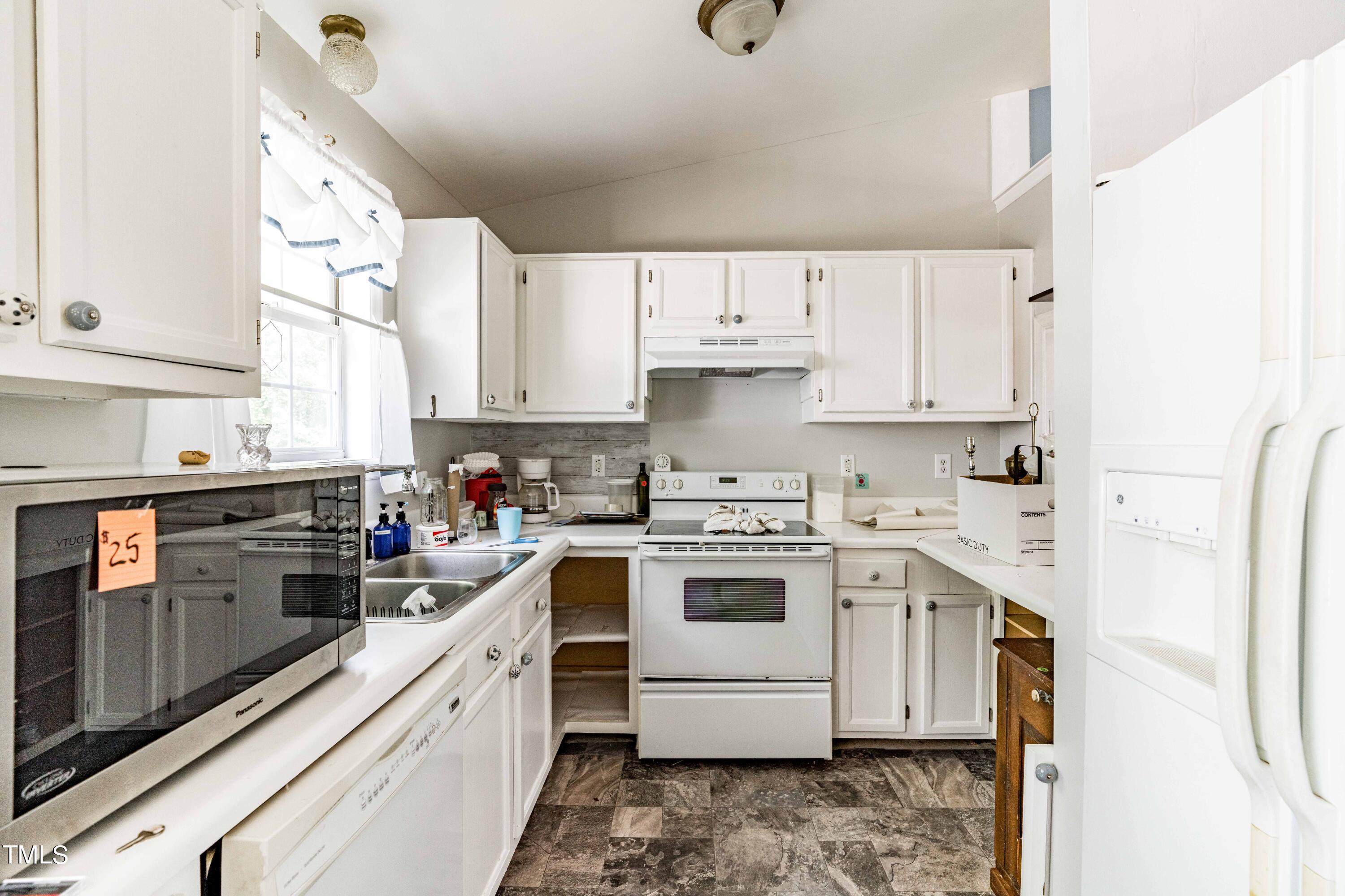 3417 Leonard Road Raleigh, NC 27610 - Photo 8 of 26 a kitchen with a white stove top oven and white cabinets