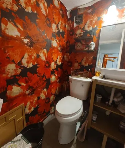 a white toilet sitting next to a shower