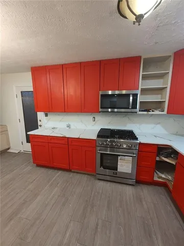 a kitchen with stainless steel appliances granite countertop a stove a sink and a microwave