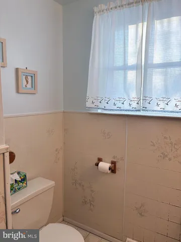 a bathroom with a toilet a sink and a window