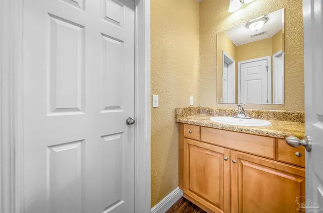 a bathroom with a granite countertop sink and a mirror