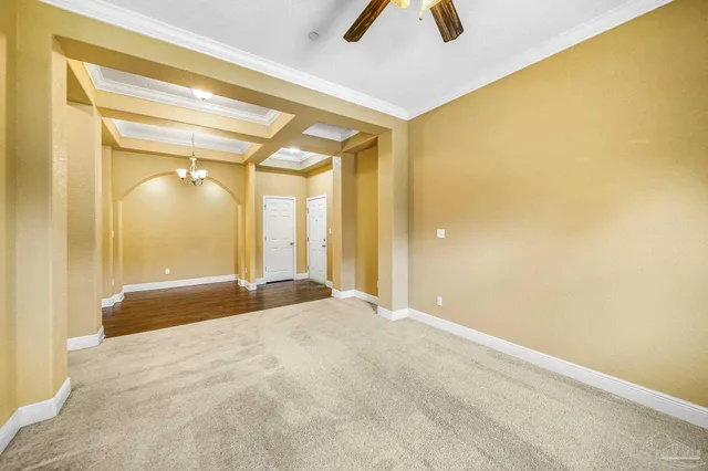 a view of an empty room with closet and a window
