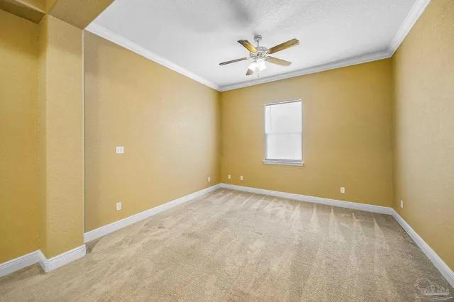 an empty room with a chandelier fan and windows