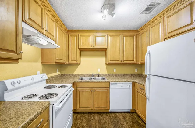 a kitchen with a stove a sink and a refrigerator