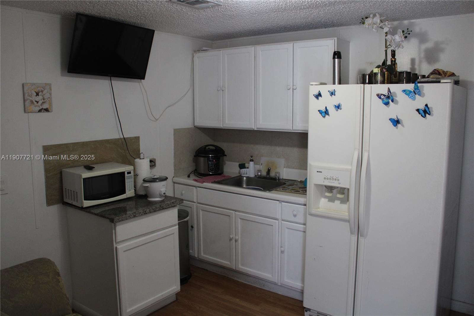 12841 Southwest 12th Terrace Miami, FL 33184 - Photo 9 of 16 a kitchen with stainless steel appliances a stove a microwave and a refrigerator