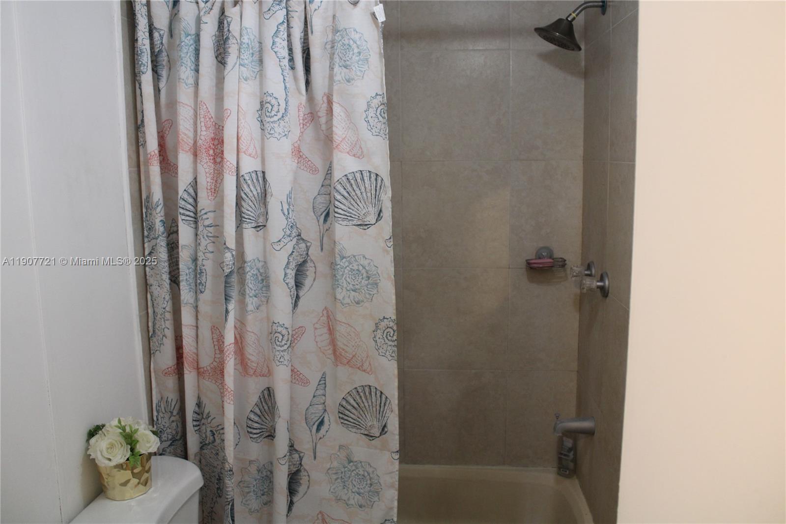 12841 Southwest 12th Terrace Miami, FL 33184 - Photo 10 of 16 a bathroom with a shower curtain and a sink