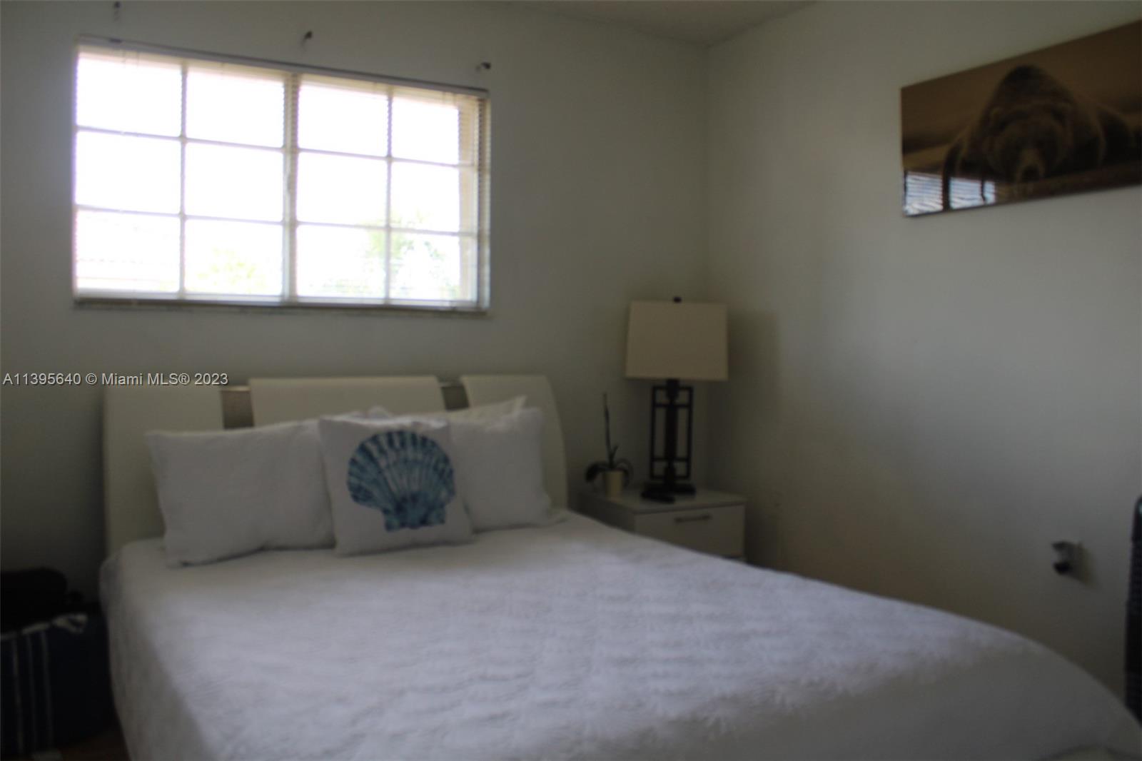 13475 Southwest 62nd Street, Unit 5 Miami, FL 33183 - Photo 13 of 32 a bed sitting in a bedroom next to a window