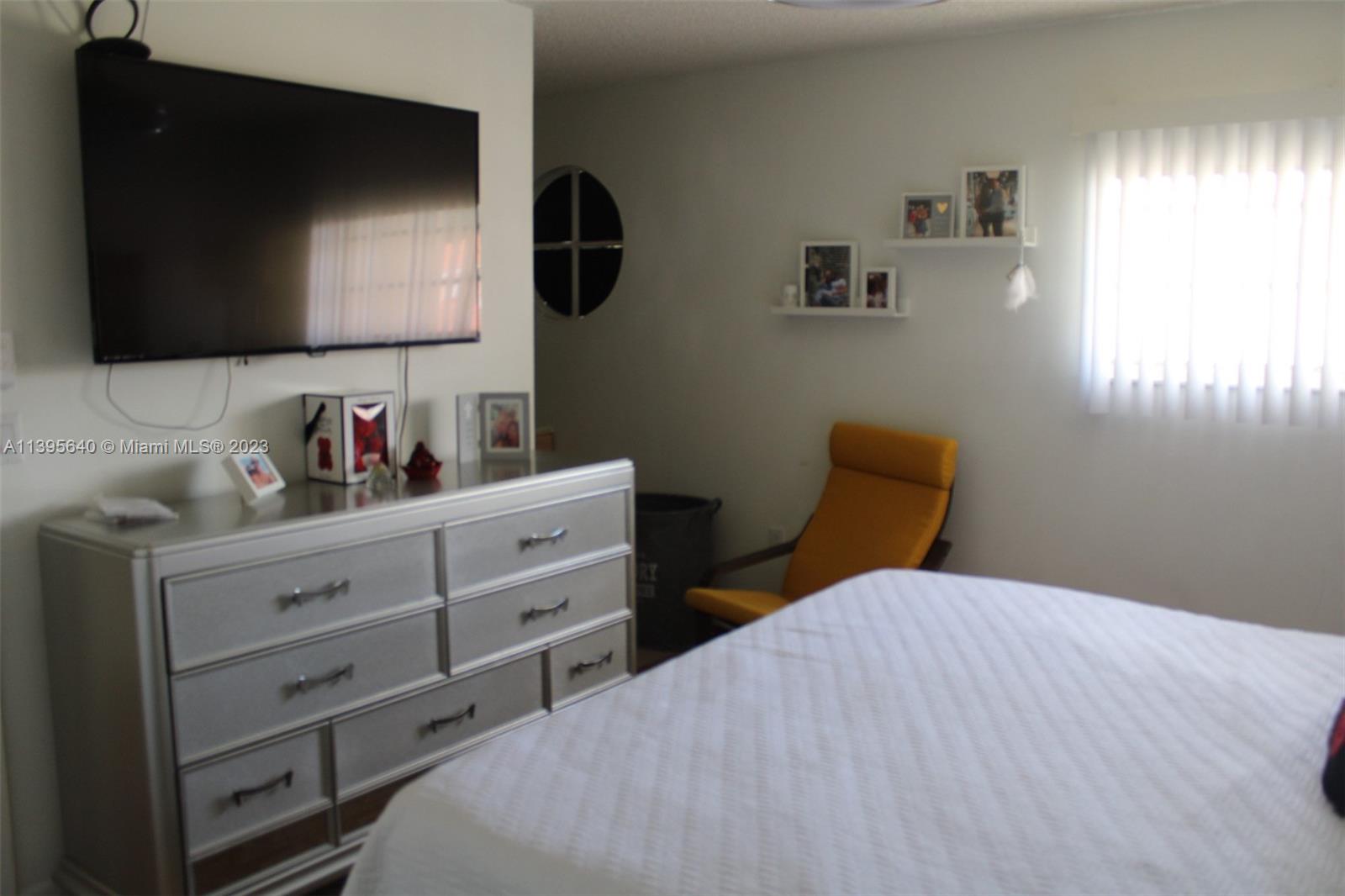 13475 Southwest 62nd Street, Unit 5 Miami, FL 33183 - Photo 15 of 32 a bedroom with a bed and flat screen tv