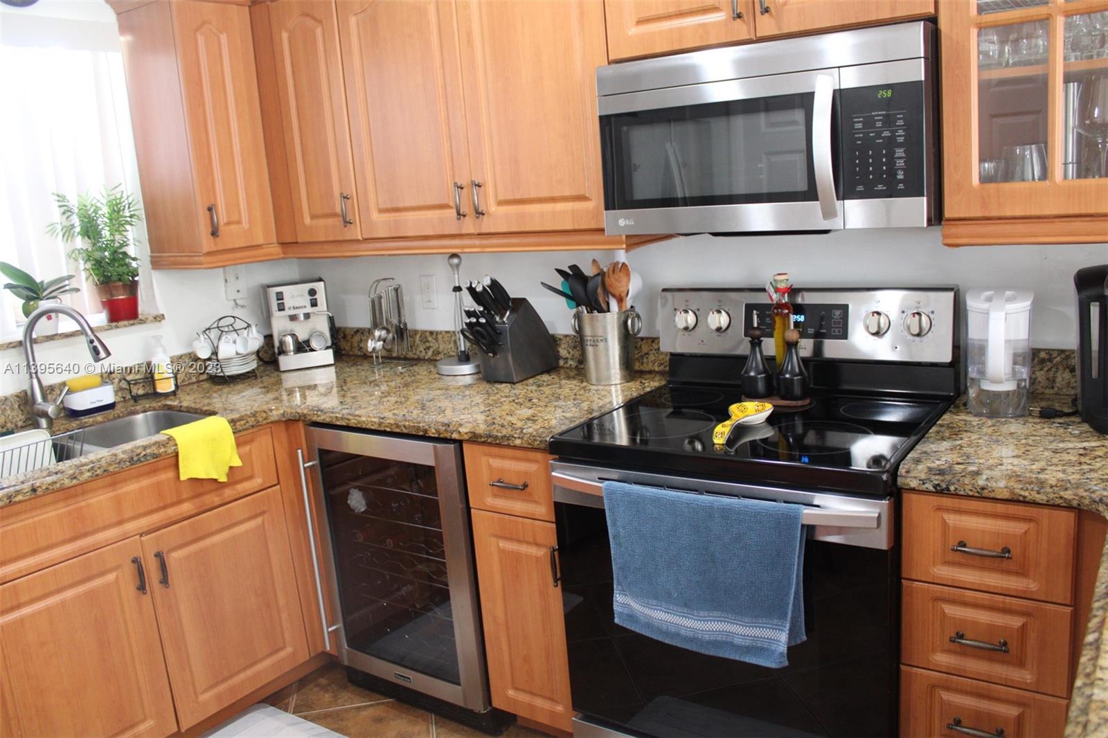 13475 Southwest 62nd Street, Unit 5 Miami, FL 33183 - Photo 21 of 32 a kitchen with stainless steel appliances granite countertop a sink stove and cabinets