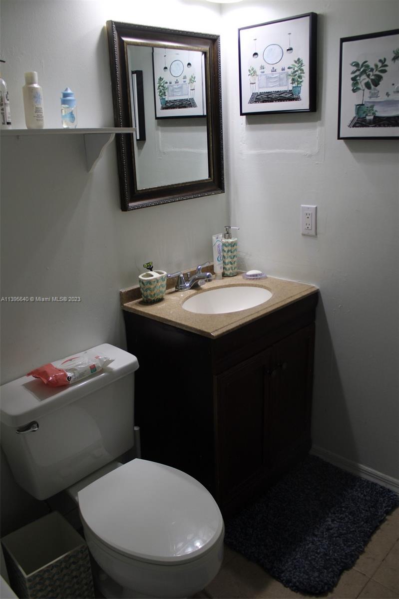 13475 Southwest 62nd Street, Unit 5 Miami, FL 33183 - Photo 24 of 32 a bathroom with a toilet a sink and mirror