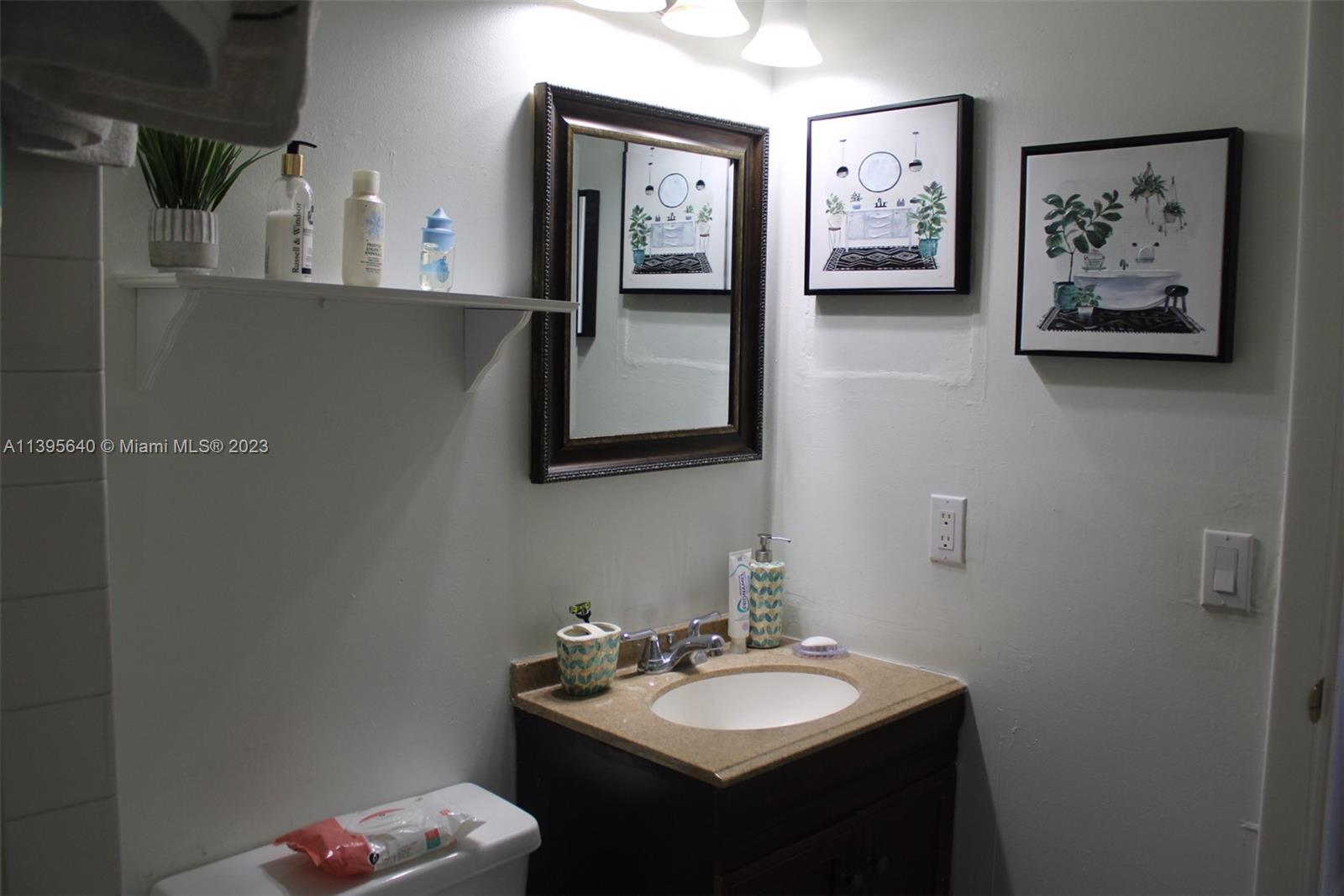 13475 Southwest 62nd Street, Unit 5 Miami, FL 33183 - Photo 25 of 32 a bathroom with a sink mirror and toilet