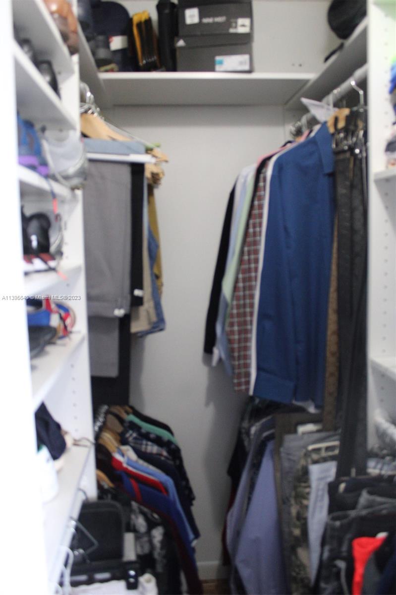 13475 Southwest 62nd Street, Unit 5 Miami, FL 33183 - Photo 30 of 32 a view of walk in closet with clothes and shoes