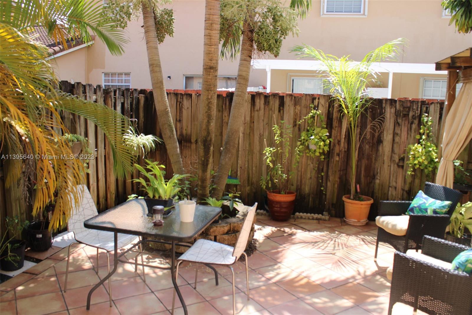 13475 Southwest 62nd Street, Unit 5 Miami, FL 33183 - Photo 31 of 32 a view of a chairs and table in backyard
