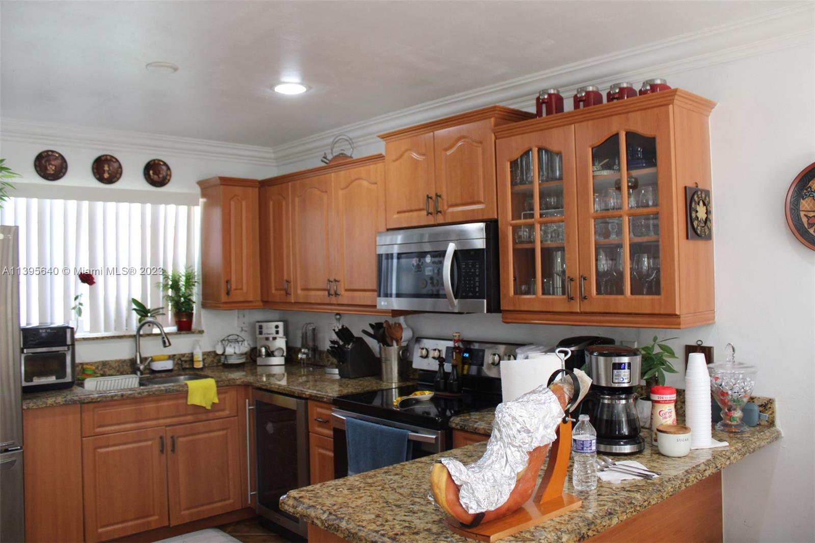 13475 Southwest 62nd Street, Unit 5 Miami, FL 33183 - Photo 10 of 32 a kitchen with stainless steel appliances granite countertop a stove a sink and a microwave