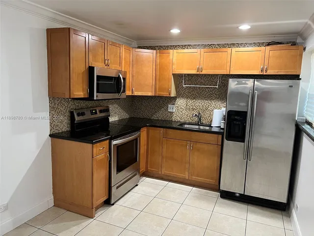 a kitchen with stainless steel appliances granite countertop a refrigerator and a stove