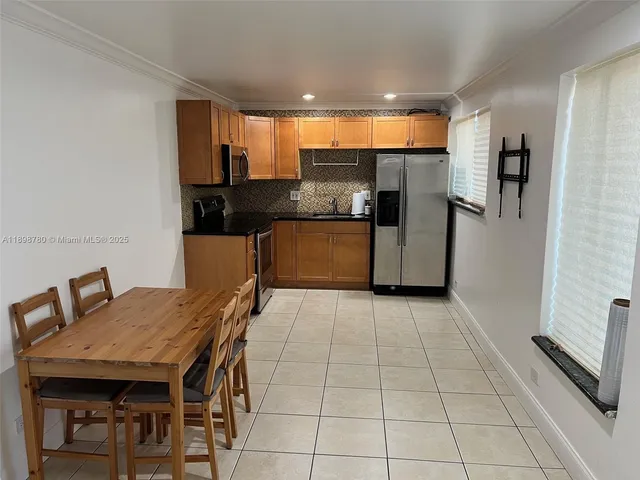 a kitchen with stainless steel appliances kitchen island granite countertop a table chairs in it and wooden floors