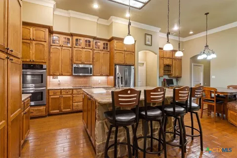 a kitchen with cabinets and chairs