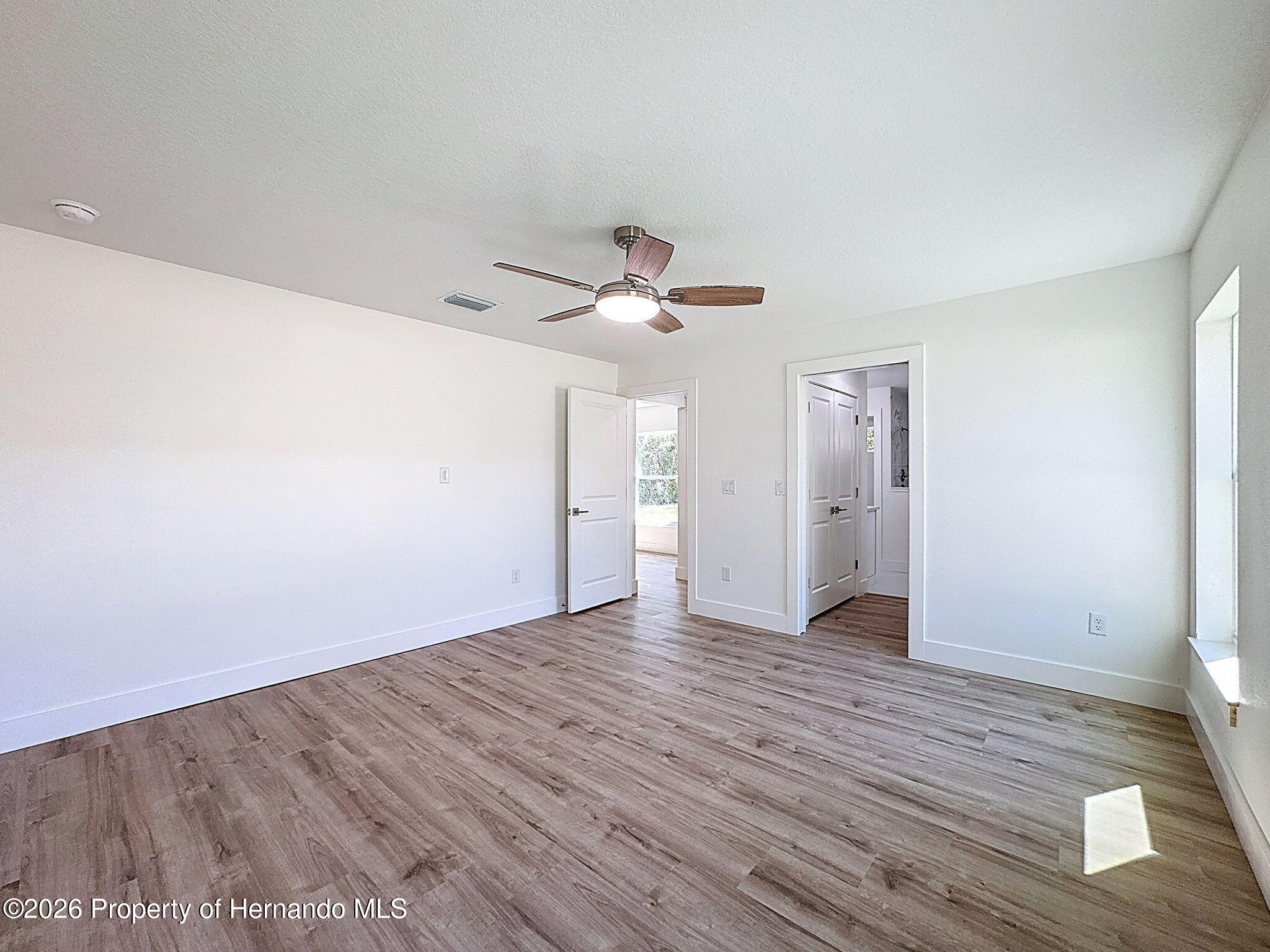 8988 Waterbird Way Weeki Wachee, FL 34613 - Photo 24 of 42 a view of an empty room with wooden floor