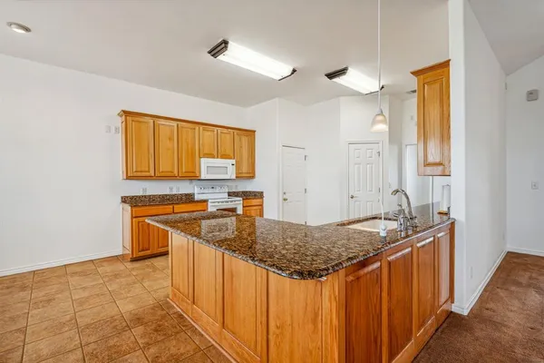 a kitchen with stainless steel appliances granite countertop a sink and a refrigerator