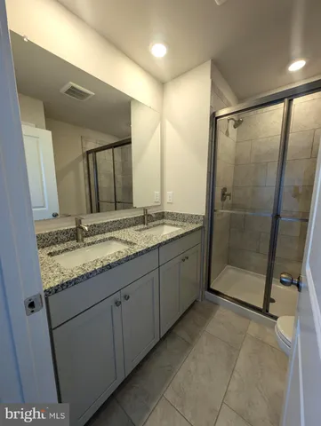 a bathroom with a granite countertop sink mirror and shower