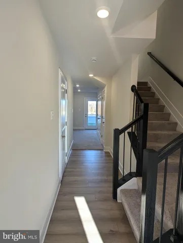 a view of a hallway with wooden floor and staircase