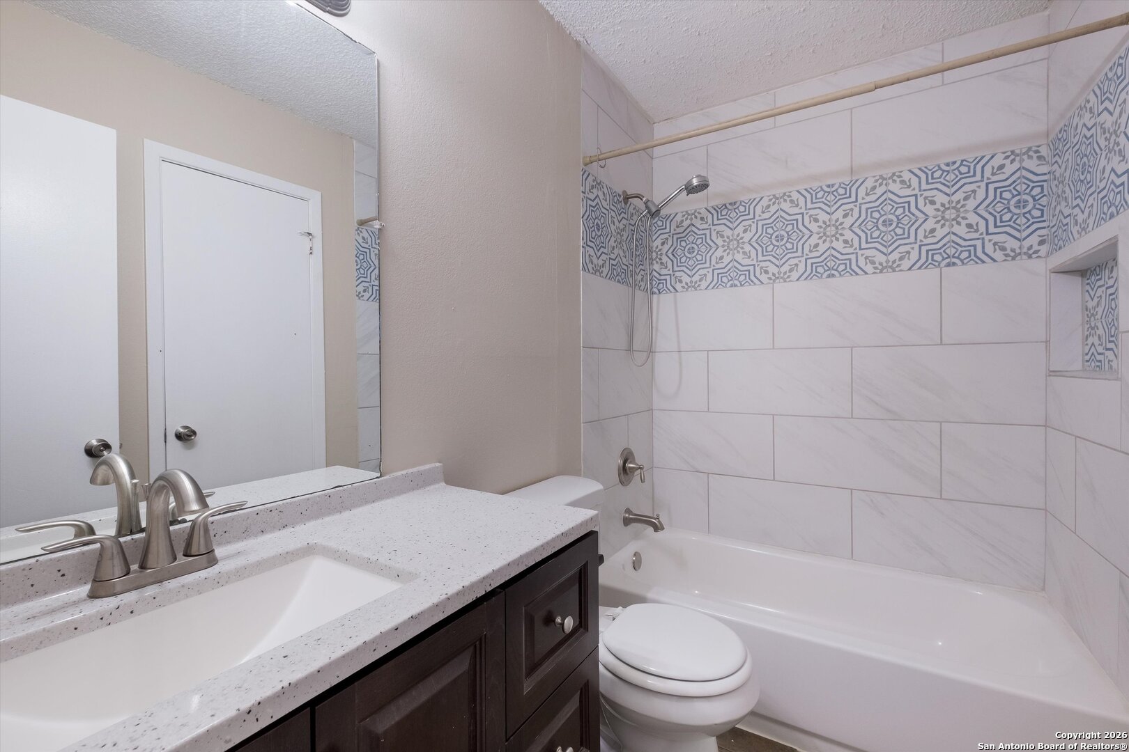 8424 8th Street Converse, TX 78109 - Photo 15 of 22 a bathroom with a granite countertop bathtub shower sink vanity and toilet