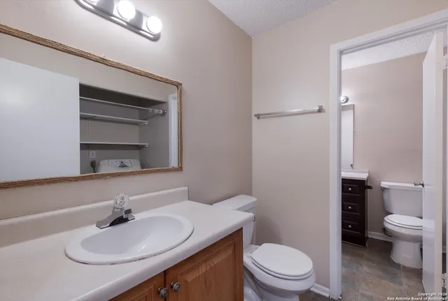 a bathroom with a sink toilet and a mirror