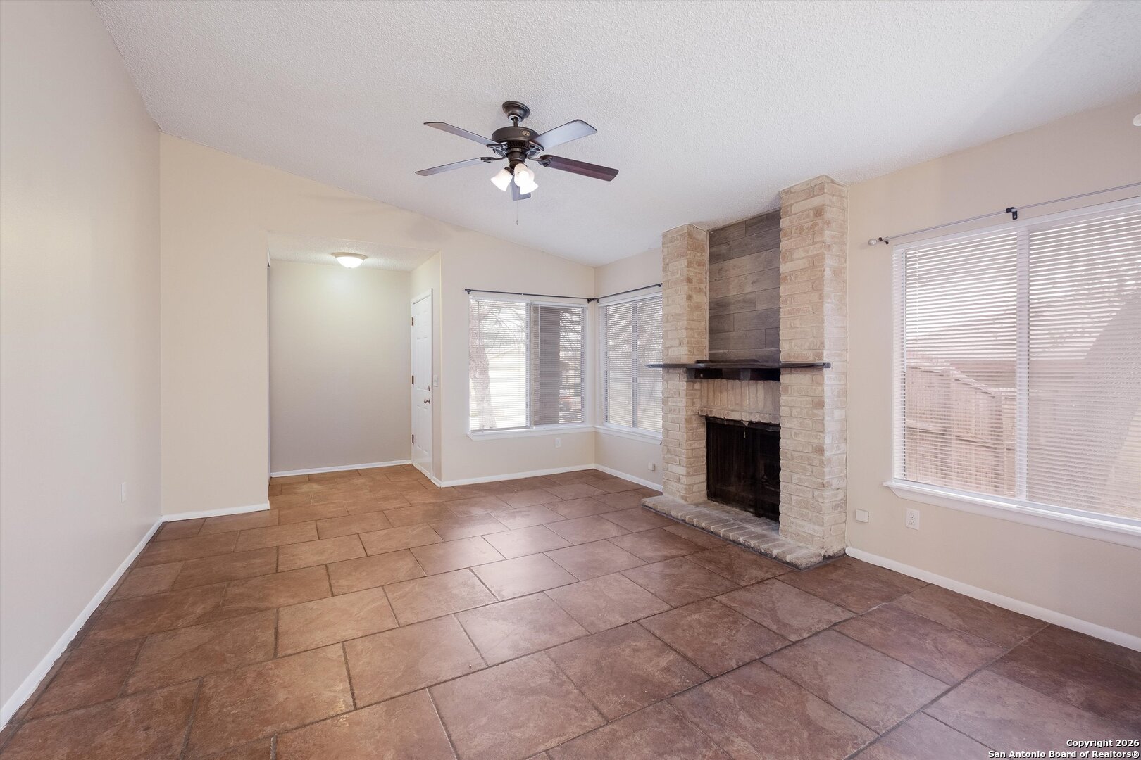 8424 8th Street Converse, TX 78109 - Photo 5 of 22 a view of an empty room with a fireplace and a window