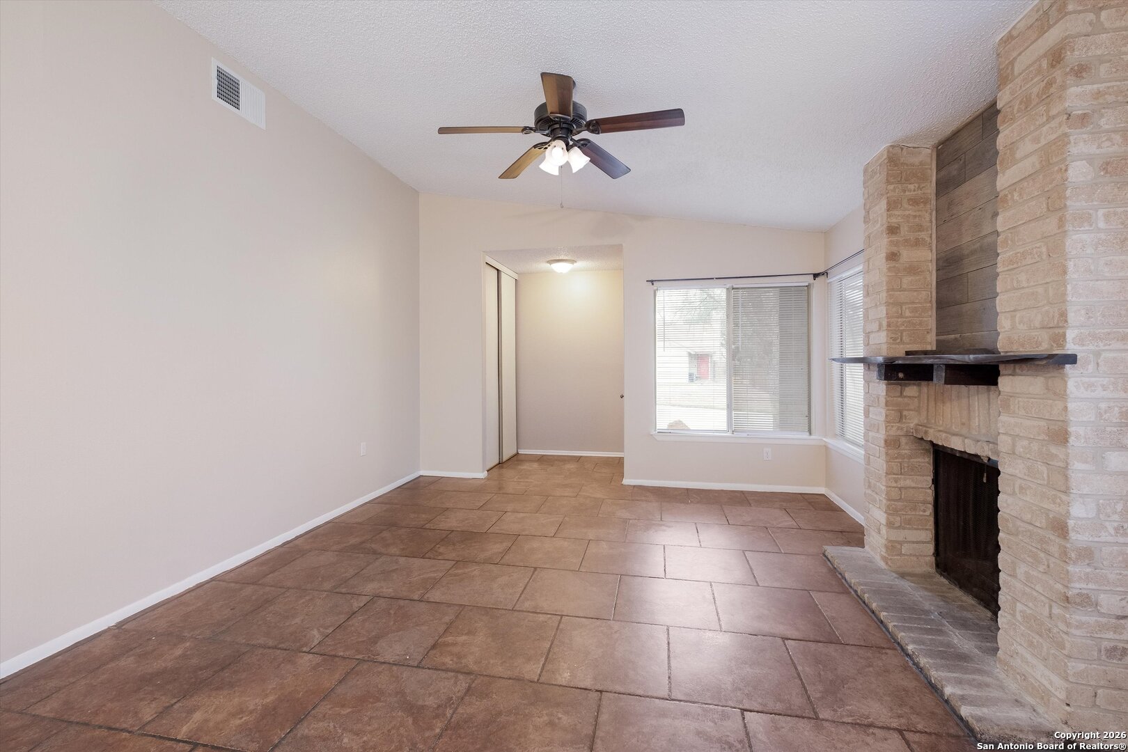 8424 8th Street Converse, TX 78109 - Photo 6 of 22 a view of an empty room with a fireplace and a window