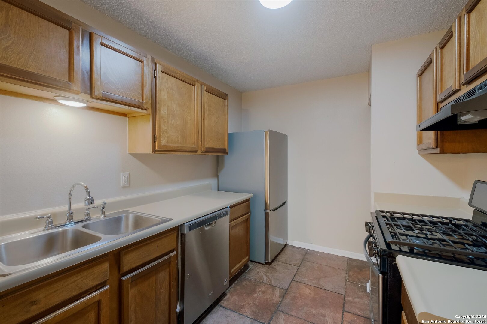 8424 8th Street Converse, TX 78109 - Photo 10 of 22 a kitchen with stainless steel appliances granite countertop a sink stove and refrigerator