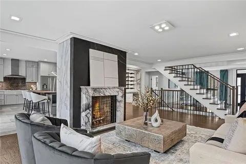 a kitchen with stainless steel appliances granite countertop a table chairs sink and cabinets