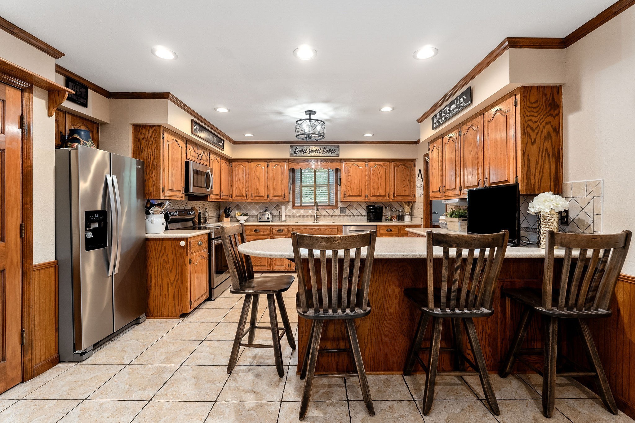 3579 Hilham Road Cookeville, TN 38506 - Photo 10 of 43 a kitchen with stainless steel appliances kitchen island granite countertop a refrigerator a stove a microwave oven a dining table and chairs with wooden floor