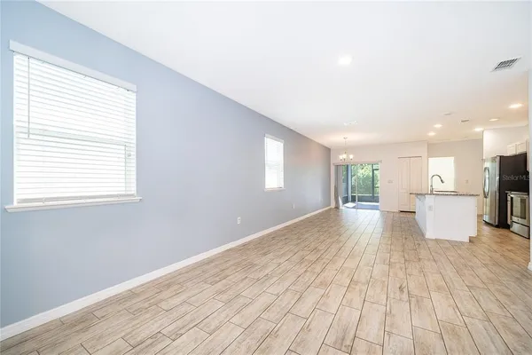 a view of a big room with wooden floor and windows