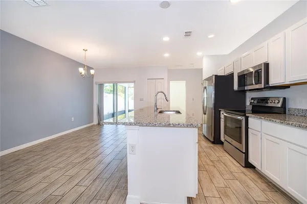 a kitchen with stainless steel appliances granite countertop a stove a sink and a refrigerator