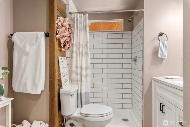 a bathroom with a toilet and a shower