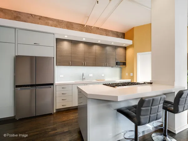 a kitchen with a refrigerator and white cabinets