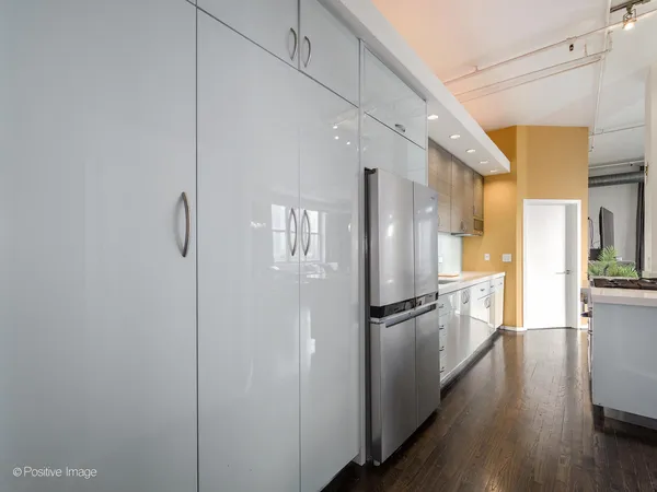 a kitchen with stainless steel appliances a refrigerator and wooden floor