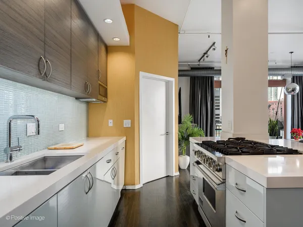 a kitchen with stainless steel appliances granite countertop a sink a stove and a refrigerator