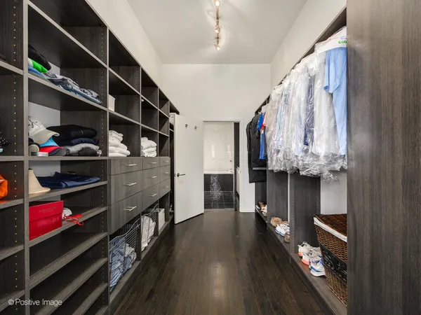 a view of walk in closet with clothes and shoes