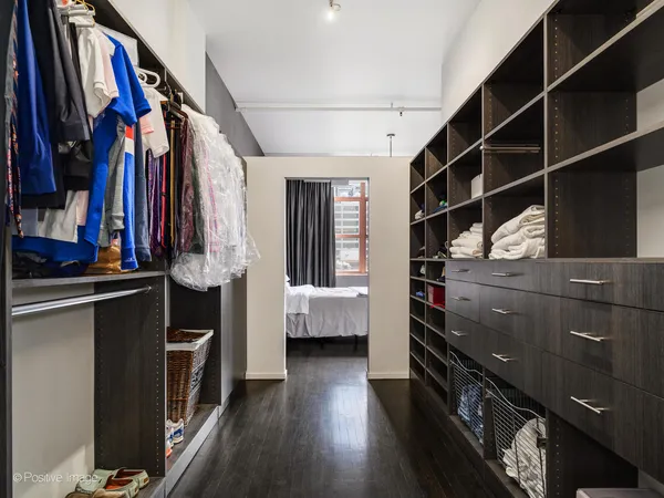a view of walk in closet with clothes and shoes