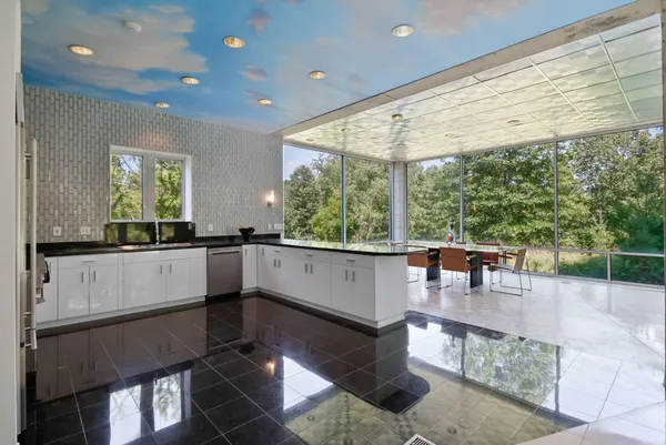 a view of hallway with an empty room and wooden floor