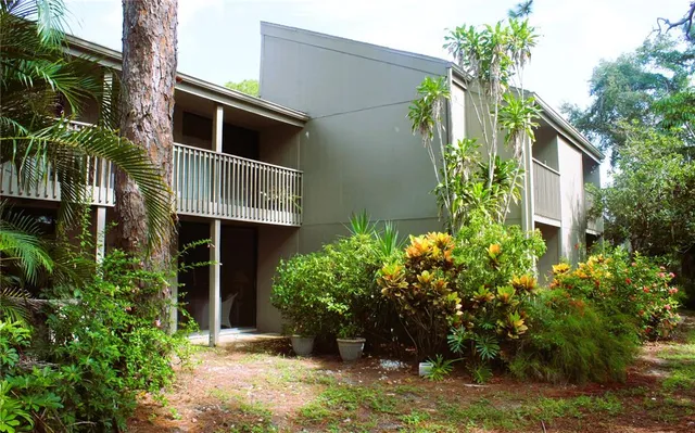 a front view of multi story residential apartment building with yard and green space