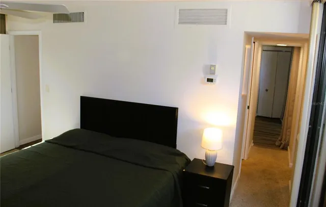 a bedroom with a bed and a lamp next to a window