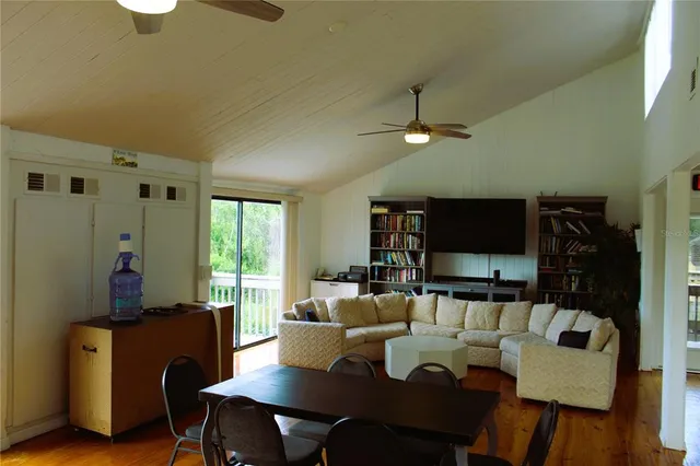 a living room with furniture a flat screen tv and kitchen view