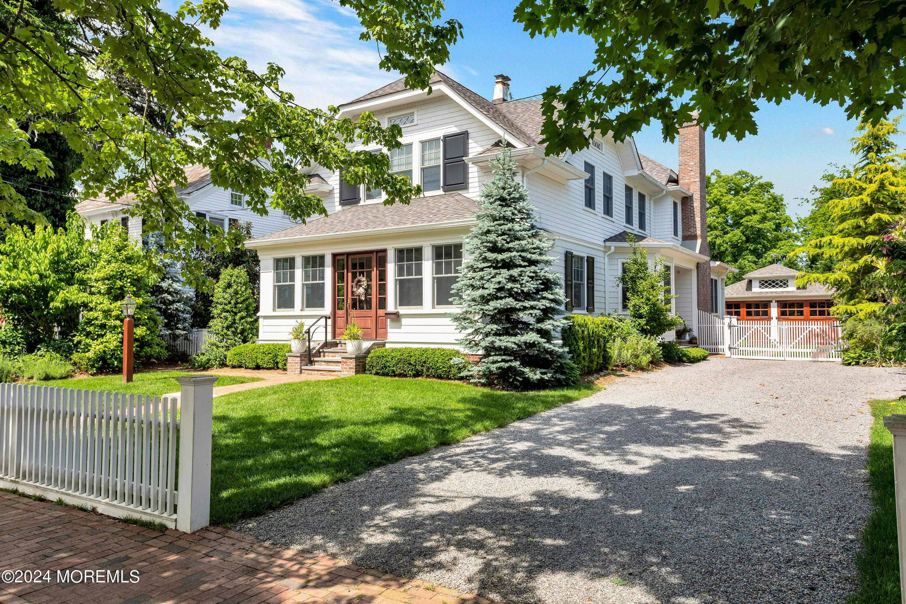 a front view of a house with a yard and trees