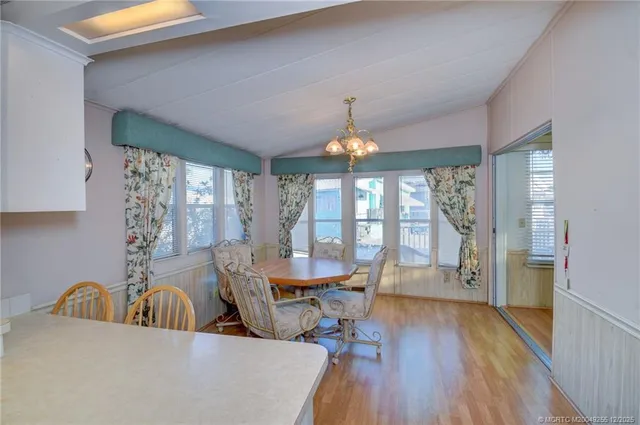 a view of a dining room with furniture a chandelier and wooden floor