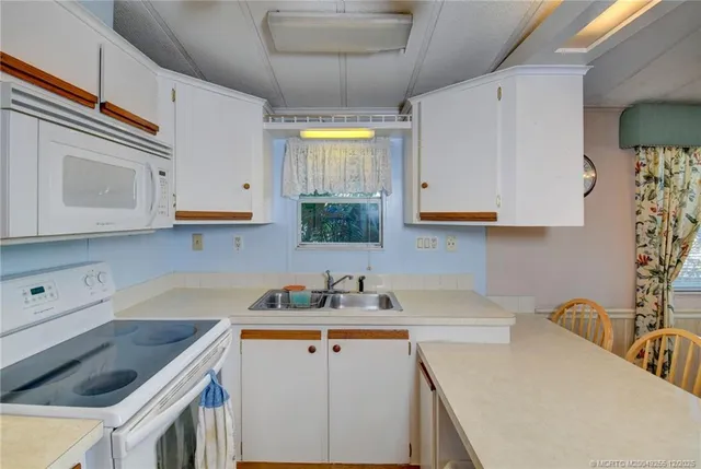 a kitchen with stainless steel appliances granite countertop a sink a stove and cabinets